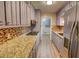 The kitchen showcases countertops, mosaic backsplash, stainless steel appliances and wood look floors at 4852 Pine Shadows Dr, Stone Mountain, GA 30088