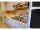 Kitchen features granite countertops, mosaic backsplash, and stainless steel gas cooktop at 4852 Pine Shadows Dr, Stone Mountain, GA 30088