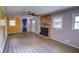 Spacious living room boasts wood-look flooring, brick fireplace, and large windows for natural light at 4852 Pine Shadows Dr, Stone Mountain, GA 30088