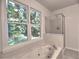 Bright bathroom featuring a soaking tub and a glass shower, illuminated by natural light at 750 Whitehall Way, Roswell, GA 30076