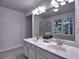 Bright bathroom with double sink vanity, large mirror, and a view of the green outdoors through the window at 750 Whitehall Way, Roswell, GA 30076