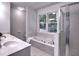 Bathroom featuring a soaking tub, glass-enclosed shower, and window with backyard views at 750 Whitehall Way, Roswell, GA 30076