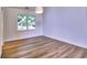 Neutral bedroom with hardwood floors, a window offering backyard views, and an overhead light fixture at 750 Whitehall Way, Roswell, GA 30076