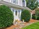 Elegant front entrance with stone walkway, manicured bushes, and decorative flower pots at 750 Whitehall Way, Roswell, GA 30076