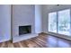 Living room featuring a painted brick fireplace, hardwood floors, and bright windows for natural light at 750 Whitehall Way, Roswell, GA 30076