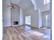 Open living room featuring a brick fireplace, hardwood floors, and vaulted ceilings at 750 Whitehall Way, Roswell, GA 30076
