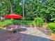Charming outdoor patio area with a red umbrella and landscaping at 750 Whitehall Way, Roswell, GA 30076