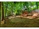 Wooded backyard featuring a playset for children, mature trees, and lush greenery at 799 Birds Se Ml, Marietta, GA 30067
