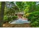 Landscaped backyard with stone patio, mature trees, and lush greenery, offering a private outdoor retreat at 799 Birds Se Ml, Marietta, GA 30067