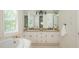 Bright bathroom with double sink vanity, large mirror, and separate soaking tub at 799 Birds Se Ml, Marietta, GA 30067
