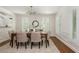 Elegant dining room with wainscoting, neutral decor, modern chandelier, and shuttered windows at 799 Birds Se Ml, Marietta, GA 30067