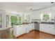 Well-lit kitchen with white cabinets, dark countertops, stainless steel appliances, and hardwood floors at 799 Birds Se Ml, Marietta, GA 30067