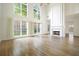 Sunlit living room boasts hardwood floors, fireplace, and large windows with backyard views at 1971 Wellesley Trce, Dunwoody, GA 30338