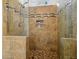 Close-up of a tiled shower with glass door, decorative accents and tiled floor at 1971 Wellesley Trce, Dunwoody, GA 30338