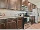 Close up of kitchen with stainless steel appliances, granite countertops and dark wood cabinets at 2102 Black Pebble Cir, Buford, GA 30519