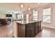 Open concept kitchen with granite countertops, dark cabinets, and seamless flow into the living area at 2102 Black Pebble Cir, Buford, GA 30519