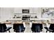 Close-up of kitchen island with granite countertop, stainless steel sink, and bar stools with place settings at 5453 Baybrook Cir, South Fulton, GA 30349