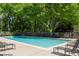 Community swimming pool surrounded by lounge chairs and lush green trees at 1445 Monroe Ne Dr # F12, Atlanta, GA 30324