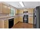 Functional kitchen featuring wood cabinets, black appliances, and tile backsplash, ready for culinary adventures at 254 Wood Duck Dr, Jonesboro, GA 30238
