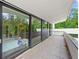 Wide balcony with gray tile flooring and black frame doors overlooking a lush green landscape at 3891 Wieuca Rd, Atlanta, GA 30342