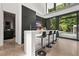 Modern bar with black cabinets, a waterfall countertop, and barstool seating next to floor-to-ceiling windows at 3891 Wieuca Rd, Atlanta, GA 30342