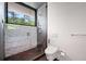 Bathroom features a modern tiled walk-in shower, toilet and a large window providing natural light at 3891 Wieuca Rd, Atlanta, GA 30342