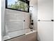 Modern bathroom features a tiled shower with a built-in niche, sleek fixtures, and a large window at 3891 Wieuca Rd, Atlanta, GA 30342