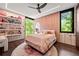 Bright bedroom featuring a ceiling fan, textured wall, large windows with green views, and display shelves at 3891 Wieuca Rd, Atlanta, GA 30342