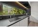 Modern kitchen featuring dark counters, a built-in cooktop, and a large window with scenic tree views at 3891 Wieuca Rd, Atlanta, GA 30342