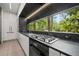 Modern kitchen featuring sleek cabinetry, black countertops, and a large window offering natural light and views at 3891 Wieuca Rd, Atlanta, GA 30342