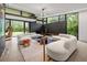 Bright living room with oversized windows, chic sofas, and views of the landscaped outdoors at 3891 Wieuca Rd, Atlanta, GA 30342