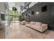 Spacious living room featuring modern sofas, exposed brick accents, polished concrete floors, and views of the pool at 3891 Wieuca Rd, Atlanta, GA 30342