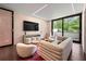 Cozy living room with designer furniture, a modern TV, and natural light overlooking the private yard at 3891 Wieuca Rd, Atlanta, GA 30342