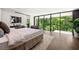 This luxurious bedroom has an ensuite bathroom and a wall of glass overlooking the trees at 3891 Wieuca Rd, Atlanta, GA 30342