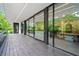 Modern patio featuring expansive sliding glass doors, a sleek overhang, and wood flooring for seamless indoor-outdoor living at 3891 Wieuca Rd, Atlanta, GA 30342