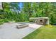 A modern pool surrounded by manicured landscaping, and an outdoor fireplace for entertaining at 3891 Wieuca Rd, Atlanta, GA 30342
