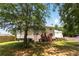 Large backyard with a deck, lush green lawn, mature trees, and wood privacy fence at 5745 Crystal Springs Way, Powder Springs, GA 30127