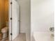 En suite bathroom featuring a toilet and a tub with white tile at 5745 Crystal Springs Way, Powder Springs, GA 30127