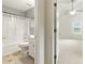 Bright bathroom featuring tub/shower combo and open door to the bedroom at 5745 Crystal Springs Way, Powder Springs, GA 30127