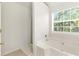 Bathroom featuring a white soaking tub and a window providing natural light at 5745 Crystal Springs Way, Powder Springs, GA 30127