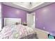 Charming purple bedroom with a tray ceiling and view to a carpeted hallway at 5745 Crystal Springs Way, Powder Springs, GA 30127