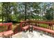 A view of the deck and the backyard, which includes mature trees, a fence, and a playset at 5745 Crystal Springs Way, Powder Springs, GA 30127