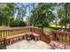 A view of the deck and the backyard, which includes mature trees, a fence, and a picnic table at 5745 Crystal Springs Way, Powder Springs, GA 30127