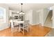 Bright dining area adjacent to the kitchen features hardwood floors and modern lighting at 5745 Crystal Springs Way, Powder Springs, GA 30127