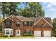 Charming two-story brick home featuring a manicured front lawn, bay window, and a two-car garage at 5745 Crystal Springs Way, Powder Springs, GA 30127