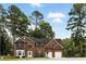 Beautiful two-story brick home with a manicured lawn, a three-car garage, and mature trees at 5745 Crystal Springs Way, Powder Springs, GA 30127