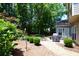 Landscaped backyard with gravel, featuring a patio with grill and mature trees at 340 Channings Lake Dr, Lawrenceville, GA 30043