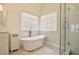 Bright bathroom featuring a freestanding tub with modern faucet and a frameless glass shower door at 340 Channings Lake Dr, Lawrenceville, GA 30043