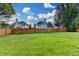 Large backyard with a lush green lawn, surrounded by a wooden fence and neighboring homes at 350 River Walk Ter, Johns Creek, GA 30024