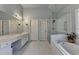 Relaxing bathroom featuring a double vanity, jacuzzi tub, and frameless shower at 350 River Walk Ter, Johns Creek, GA 30024